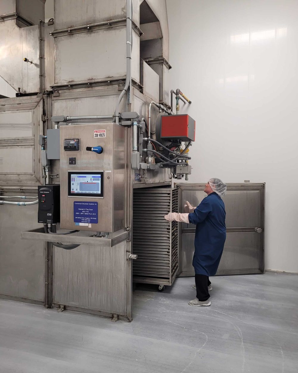 A technician at the dehydrator control panel